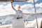 Attractive blond female skipper navigating the fancy catamaran sailboat on sunny summer day on calm blue sea water.