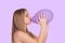 Attractive blond girl swelling a purple balloon