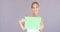 Attractive blond woman holding a blank green sign