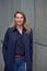 Attractive blond woman leaning against an urban concrete wall