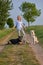 Attractive blond woman on a rural path with her three dogs
