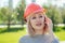 Attractive blonde boss woman builder in an orange helmet in the park on a background of green grass