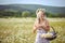 Attractive blonde in chamomile field. Young woman in wreath