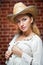 Attractive blonde girl with straw hat and white blouse