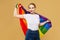 Attractive blonde made posing with a rainbow LGBT flag. photo shoot in the studio on a yellow background