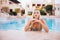 Attractive blonde Slim Woman at the Edge of Beautiful Pool Smiling on camera.