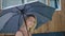 Attractive blonde uses an umbrella during the rain. A woman under a summer shower.