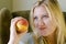 Attractive blonde woman holding peach