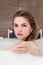 Attractive blonde woman lying in bathtub in foam in hotel.