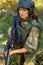 Attractive brave military woman with a gun in forest, survival in wild forest