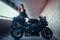 Attractive brave woman is sitting on her motobike in tunnel