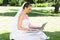 Attractive bride using laptop in garden