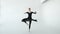 Attractive brunette ballerina in white pointe dancing in a white dance studio 20s 1080p slow motion