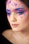 Attractive brunette with bright art make-up. Colored Smokey eyes and blue eyebrows.