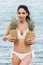 attractive brunette girl in bikini holding sweet pineapples