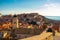 Attractive brunette standing on the city walls of the old town of Dubrovnik, small houses and rooftops surrounding the whole