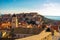 Attractive brunette standing on the city walls of the old town of Dubrovnik, small houses and rooftops surrounding the whole