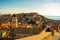 Attractive brunette standing on the city walls of the old town of Dubrovnik, small houses and rooftops surrounding the whole