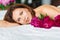 attractive brunette topless woman with a bouquet of peonies on the bed.