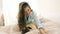Attractive brunette woman in bed taking selfie with her small dog pug. Video footage. Good weekend morning mood. Playing
