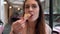 Attractive brunette woman holding slice of pizza and biting it. Hungry girl have a dinner in fast food restaurant.