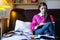 Attractive brunette woman student reading/ studying in her girly room