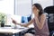 Attractive business woman talking with collegues on the mobile phone while sitting in the office desk