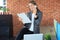 Attractive business woman talking with collegues on the mobile phone while sitting on the office desk