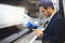 Attractive businessman texting message in mobile phone while waiting for train in metro