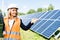 attractive businesswoman in hardhat holding digital tablet and pointing with hand.