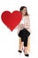 Attractive businesswoman holds valentine day heart and points to side