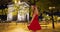 Attractive carefree woman twirling in red sundress on Paris street