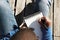 Attractive casually dressed young black male student making notes in copybook, preparing for lesson at university.