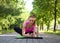 Attractive caucasian fit woman does one leg stretching on the mat. Urban training in summer outdoor, selective focus.