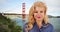 Attractive Caucasian smiling at camera, famous Golden Gate bridge in background