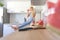 Attractive caucasian woman drinking homemade fruit juice sitting on kitchen counter. Housewife relaxing in the kitchen.