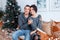 Attractive cheerful man and woman sitting near christmas tree hugging. couple cuddling. New year`s eve