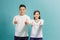 Attractive cheerful young lovers showing thumbs up