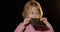 Attractive child eating a huge block of chocolate. Cute blonde girl
