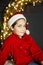 Attractive child wearing Santa Claus hat. Child celebrates Christmas