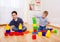 Attractive children playing with constructor on floor at home