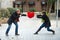 Attractive couple fighting over a love heart pillow