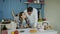 Attractive couple meet and kiss in the kitchen at breakfast time at home