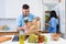 Attractive couple of two young people unpacking together fresh products from market in kitchen. Happy family concept.