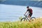 Attractive cyclist riding the mountain bike on the summer trail above the river.