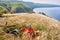 The attractive cyclist sitting on the grass on the meadow with mountain bike above river.