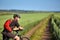 Attractive cyclist standing with mountain bicycle in field with blue sky on a background.