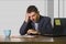 Attractive depressed and frustrated man working at office computer desk desperate and overwhelmed with financial business problem