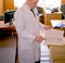 Attractive doctor in a white coat writes the patientâ€™s story in the office of his clinic