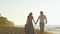 Attractive enloved young pair walking on the beach together. Romantic honeymoon concept